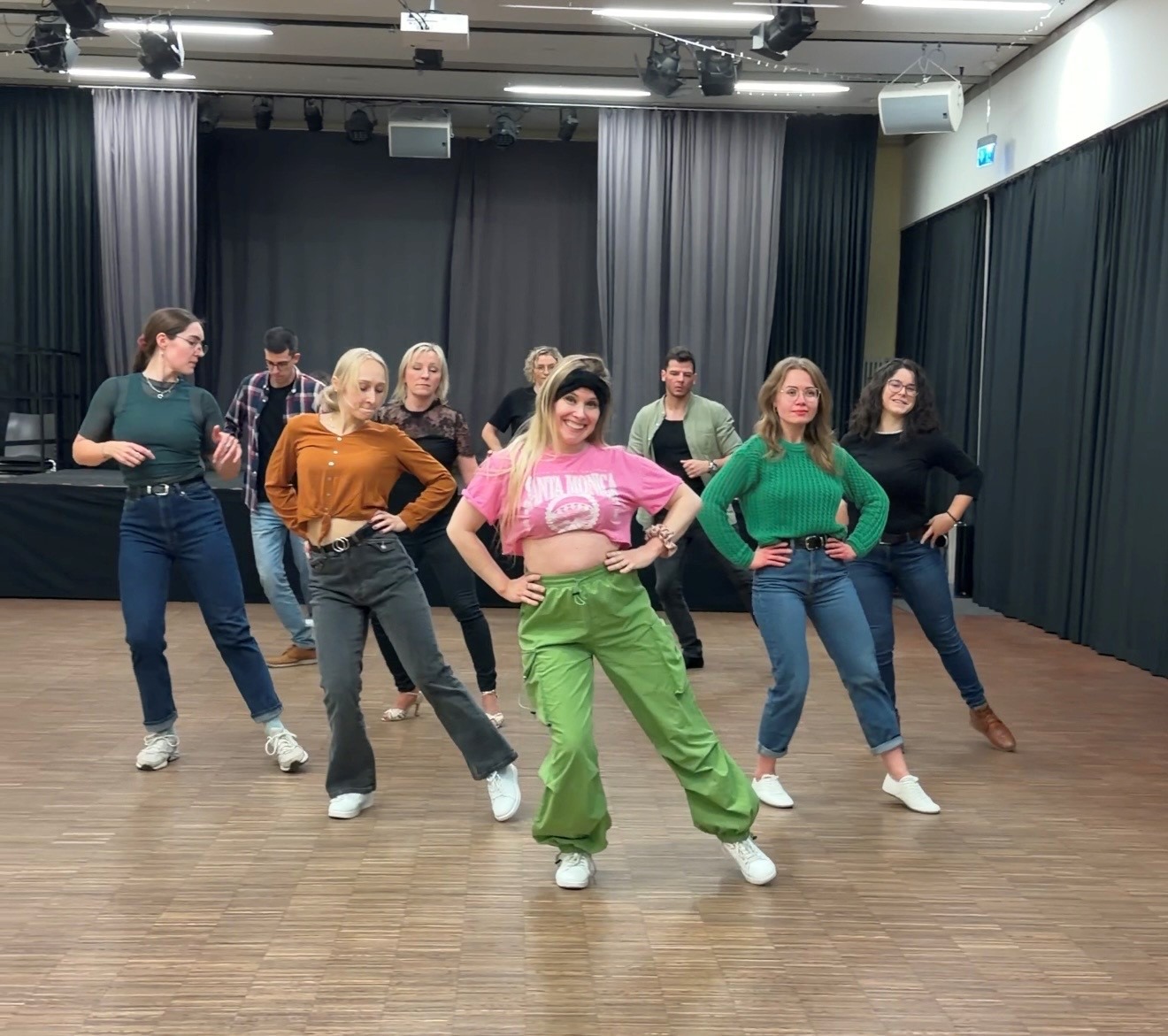 Kursteilnehmer*innen bei einem Bachata-Tanzschritt.